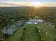 Stunning aerial view of the community, golf course, tennis courts, clubhouse, pool and the surrounding landscape at sunrise at 3910 Somerset Dr, Durham, NC 27707