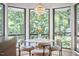 Charming breakfast nook surrounded by windows, creating a serene dining experience with natural light and tree views at 3910 Somerset Dr, Durham, NC 27707