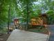 View of the back of house, beautiful wood deck, and stone driveway framed by mature trees at 3910 Somerset Dr, Durham, NC 27707