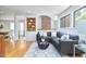 Bright living room with sectional sofa, bookshelf, large windows, and hardwood floors throughout the house at 3910 Somerset Dr, Durham, NC 27707