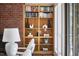 Living room featuring a large wooden bookcase built into a brick wall at 3910 Somerset Dr, Durham, NC 27707