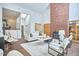 Airy living room boasts soaring ceilings, a striking brick fireplace, and an abundance of natural light at 3910 Somerset Dr, Durham, NC 27707