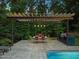 Covered patio area with outdoor dining table, grill and view of the pool at 3910 Somerset Dr, Durham, NC 27707