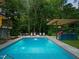 Backyard pool features a stylish outdoor kitchen and lounge area, perfect for entertaining and relaxing in luxury at 3910 Somerset Dr, Durham, NC 27707