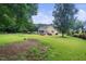 Expansive backyard with a covered patio, outdoor seating, and mature landscaping at 3916 Rustic Mill Dr, Apex, NC 27539