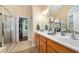 Bathroom with a double sink vanity, a walk-in shower, and a view into the walk-in closet at 3916 Rustic Mill Dr, Apex, NC 27539