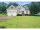 Charming two-story home with a well-manicured lawn and attached two-car garage in a lush green neighborhood at 3916 Rustic Mill Dr, Apex, NC 27539