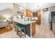 Stylish kitchen island with barstool seating, granite countertops, and oak cabinets adjacent to living room at 3916 Rustic Mill Dr, Apex, NC 27539