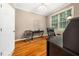 Home office with hardwood floors, a ceiling fan, and a large window with a view of the yard at 3916 Rustic Mill Dr, Apex, NC 27539