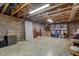 Unfinished basement with exposed beams, brick walls, and ample storage space at 4272 Boyd Wright Rd, Burlington, NC 27215