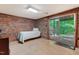 Cozy bedroom featuring brick accent wall and access to outdoor patio at 4272 Boyd Wright Rd, Burlington, NC 27215