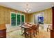 Cozy dining room with vintage wallpaper, a chandelier, and a window overlooking the backyard at 4272 Boyd Wright Rd, Burlington, NC 27215