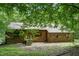 Charming home featuring wood and brick exterior, complemented by lush greenery, offering a serene and private setting at 4272 Boyd Wright Rd, Burlington, NC 27215