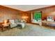 Comfortable living room featuring cozy furniture, a window seat with a view of nature, and wood paneling at 4272 Boyd Wright Rd, Burlington, NC 27215