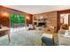 Warm living room features a brick fireplace, wood paneling, cozy furniture, and a sliding door to the outdoor deck at 4272 Boyd Wright Rd, Burlington, NC 27215