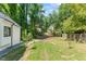 Lush backyard with a grassy lawn, mature trees, and charming landscaping at 4408 Queenstown Ct, Raleigh, NC 27612