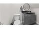 Bathroom offers gray vanity with black countertop and round mirror at 4408 Queenstown Ct, Raleigh, NC 27612