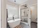 Elegant bathroom featuring a soaking tub, walk-in shower, and modern fixtures at 4408 Queenstown Ct, Raleigh, NC 27612