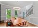 Bright dining room features a modern chandelier, wood table with seating, and an open staircase at 4408 Queenstown Ct, Raleigh, NC 27612