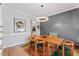 Dining area boasts an elegant chandelier, wood table and modern chairs, with views into the kitchen at 4408 Queenstown Ct, Raleigh, NC 27612