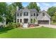 Inviting two-story home with a well-manicured lawn, painted brick and modern farmhouse accents at 4408 Queenstown Ct, Raleigh, NC 27612
