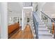 Bright foyer with hardwood floors, a staircase, and views into the living room with a leather couch at 4408 Queenstown Ct, Raleigh, NC 27612