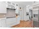 Updated kitchen features white cabinetry, stainless steel appliances, and marble countertops at 4408 Queenstown Ct, Raleigh, NC 27612