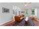 Inviting living room with hardwood floors and decorative rug, featuring leather couches and white accents at 4408 Queenstown Ct, Raleigh, NC 27612