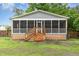 Back of house featuring a screened-in porch with wooden steps and railing leading to the backyard at 4575 Wendell Blvd, Wendell, NC 27591