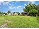 Expansive backyard with a lush lawn, mature trees, and a charming screened-in porch at 4575 Wendell Blvd, Wendell, NC 27591