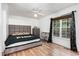 Bedroom with laminated wood floor, featuring a window and a gray upholstered bed, desk, and dresser at 4575 Wendell Blvd, Wendell, NC 27591