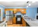 Well-lit kitchen featuring wood cabinets, stainless steel appliances, laminate countertops, and light blue walls at 4575 Wendell Blvd, Wendell, NC 27591