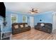 Comfortable living room with light blue walls, wood floors, ceiling fan, and two plush brown sofas at 4575 Wendell Blvd, Wendell, NC 27591