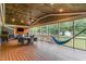 Spacious screened-in porch with a ceiling fan, dining set, TV, and a relaxing hammock at 4575 Wendell Blvd, Wendell, NC 27591