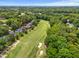 Expansive aerial view of a golf course community surrounded by mature trees, a pond, and distant city skyline at 4705 Royal Troon Dr, Raleigh, NC 27604