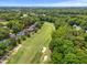 Expansive aerial view of a golf course community surrounded by mature trees, a pond, and distant city skyline at 4705 Royal Troon Dr, Raleigh, NC 27604