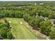 Aerial view showcasing the golf course adjacent to homes with lush landscaping at 4705 Royal Troon Dr, Raleigh, NC 27604