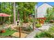 Scenic backyard featuring a charming wooden bridge, lush greenery, and landscaped garden areas at 4705 Royal Troon Dr, Raleigh, NC 27604
