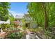 Charming backyard oasis with stone pathways, lush gardens, mature trees, and a cozy seating area at 4705 Royal Troon Dr, Raleigh, NC 27604