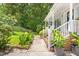 Inviting front porch and walkway lined with lush greenery and plants at 4705 Royal Troon Dr, Raleigh, NC 27604