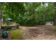 Wide shot of home's wooded back yard shows deck and storage shed at 4710 Rollingwood Dr, Durham, NC 27713