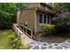 Exterior shot of home with wooden wheelchair ramp, landscaping, and stone pathway at 4710 Rollingwood Dr, Durham, NC 27713