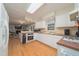 Well-lit kitchen with white cabinets, modern appliances, and hardwood floors at 4710 Rollingwood Dr, Durham, NC 27713