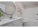 Bright bathroom with a white vanity, round mirror, and a clean, tiled shower-tub combination at 4720 Brigadoon Dr, Durham, NC 27705
