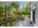 Inviting back porch with gray wood flooring and railings offers a serene view of the professionally landscaped backyard at 4777 Helena Moriah Rd, Rougemont, NC 27572