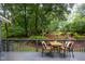 Backyard deck area with a table and seating overlooking a landscaped backyard with mature trees at 4777 Helena Moriah Rd, Rougemont, NC 27572