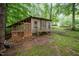 Rustic chicken coop with screened enclosure nestled in a lush backyard, offering a charming and functional addition at 4777 Helena Moriah Rd, Rougemont, NC 27572