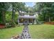Charming two-story home with a stone pathway and inviting front porch, nestled among mature trees at 4777 Helena Moriah Rd, Rougemont, NC 27572