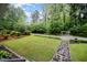 Beautifully landscaped front yard with a stone pathway leading to the house and garage at 4777 Helena Moriah Rd, Rougemont, NC 27572