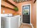 Charming laundry room with wood shelves, Samsung washer and dryer, and unique floral wallpaper on the ceiling at 4777 Helena Moriah Rd, Rougemont, NC 27572